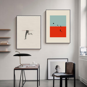 Two contemporary nordic figure wall art prints hanging above a table and chairs