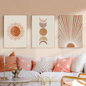Three red and cream sun and moon scene wall art prints hanging above a sofa