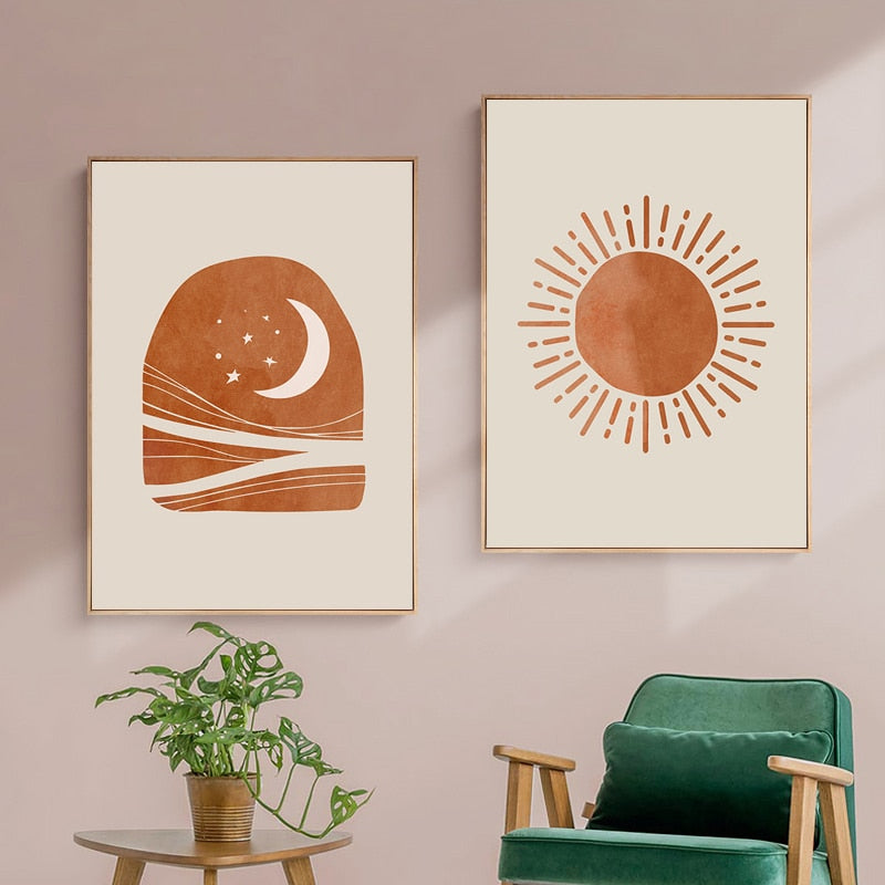 Red and cream sun and moon scene wall art print hanging on a wall above a green chair