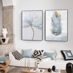Abstract scandinavian blue flower and feather wall art prints hanging above a sofa