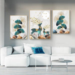 Load image into Gallery viewer, Three gold green and grey leaf and deer wall art print hanging above a light grey sofa.
