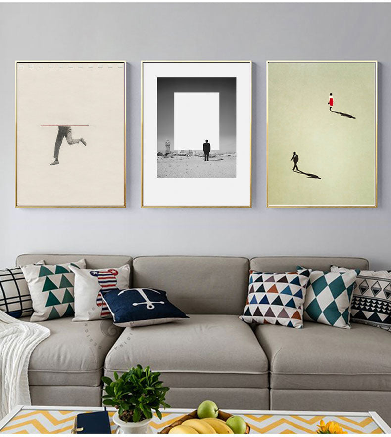 Three contemporary nordic figure wall art prints hanging above a grey sofa