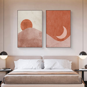 Red pink and cream sun and moon scene wall art prints hanging above a bed.